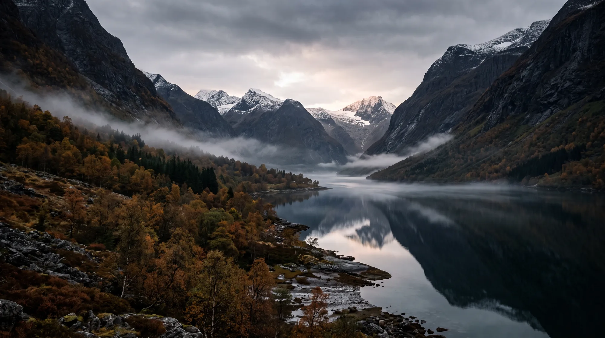 Fjordvann i morgentåke mellom bratte fjellsider